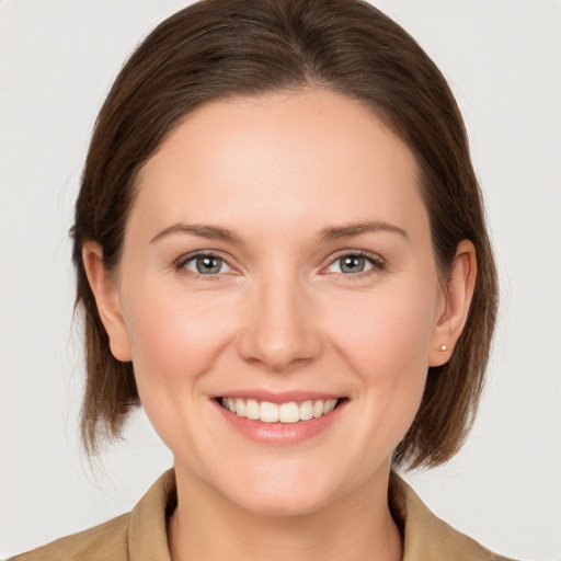 Joyful white young-adult female with medium  brown hair and grey eyes