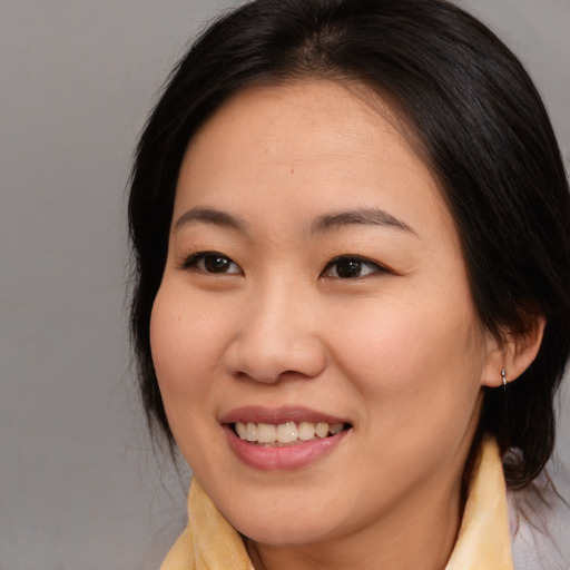 Joyful asian young-adult female with medium  brown hair and brown eyes