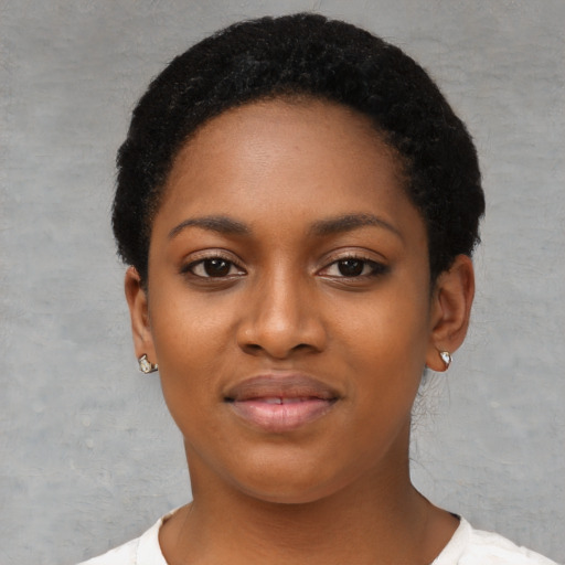 Joyful black young-adult female with short  black hair and brown eyes