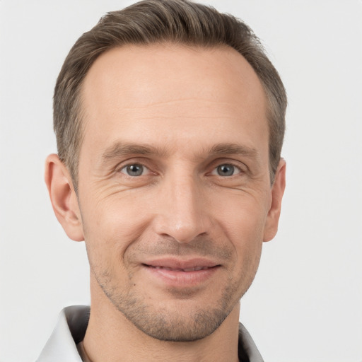 Joyful white adult male with short  brown hair and brown eyes