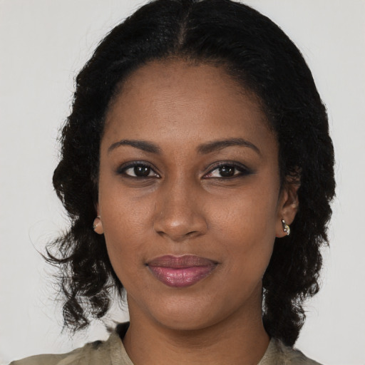 Joyful black young-adult female with long  black hair and brown eyes
