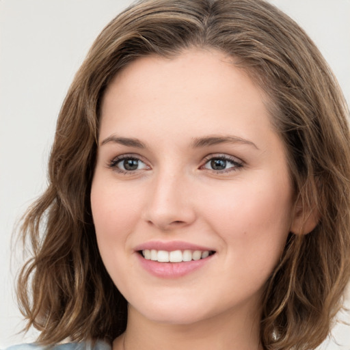 Joyful white young-adult female with medium  brown hair and green eyes