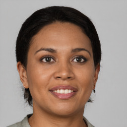 Joyful latino young-adult female with medium  brown hair and brown eyes