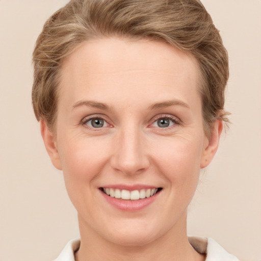 Joyful white young-adult female with short  brown hair and grey eyes