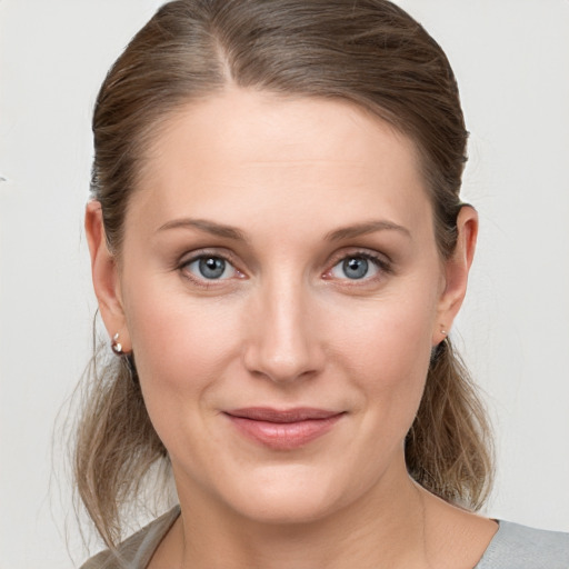 Joyful white young-adult female with medium  brown hair and grey eyes