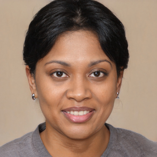 Joyful black young-adult female with short  black hair and brown eyes