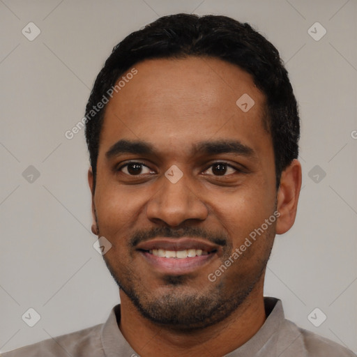 Joyful black young-adult male with short  black hair and brown eyes