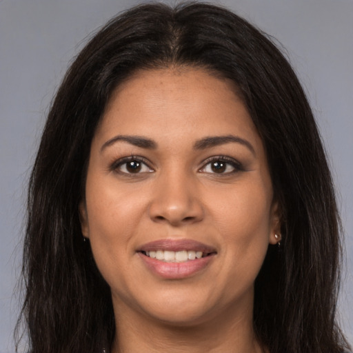 Joyful latino young-adult female with long  brown hair and brown eyes