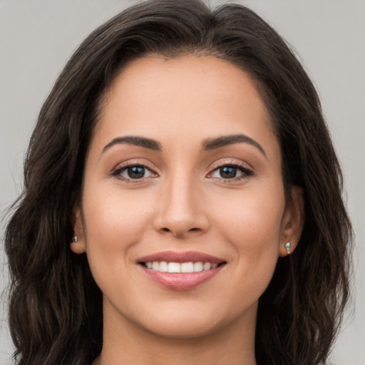 Joyful white young-adult female with long  brown hair and brown eyes