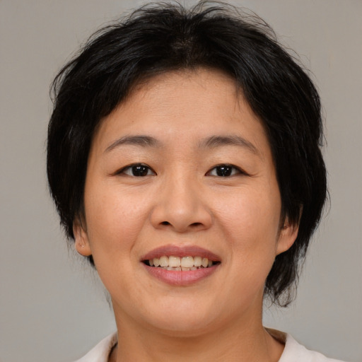 Joyful asian adult female with medium  brown hair and brown eyes