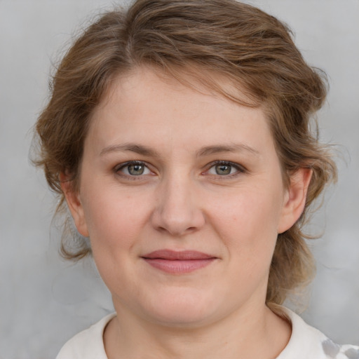 Joyful white young-adult female with medium  brown hair and blue eyes