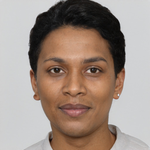 Joyful black young-adult female with short  black hair and brown eyes