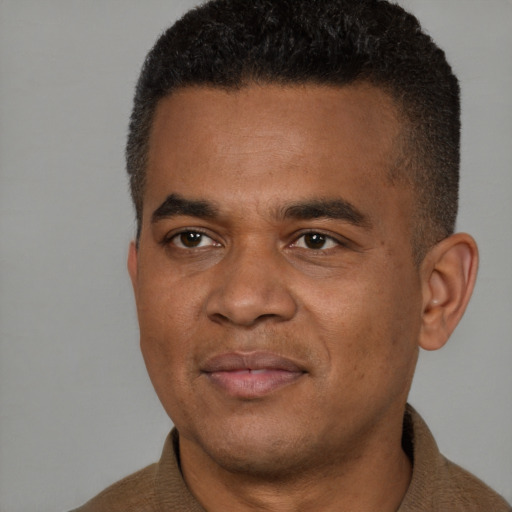 Joyful black young-adult male with short  brown hair and brown eyes