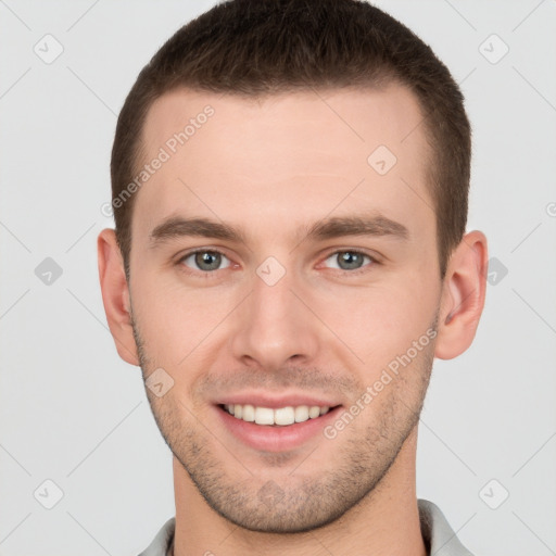 Joyful white young-adult male with short  brown hair and grey eyes