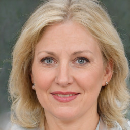 Joyful white adult female with medium  brown hair and blue eyes