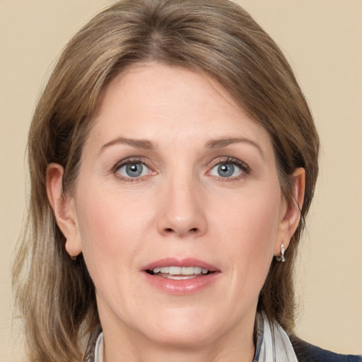 Joyful white adult female with medium  brown hair and grey eyes