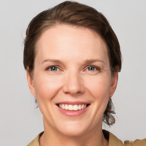 Joyful white young-adult female with medium  brown hair and grey eyes