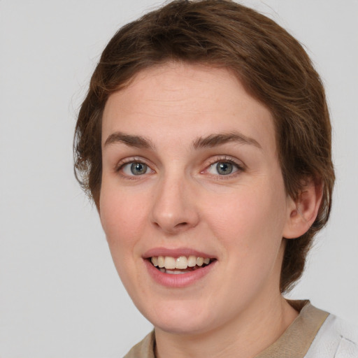 Joyful white young-adult female with medium  brown hair and green eyes