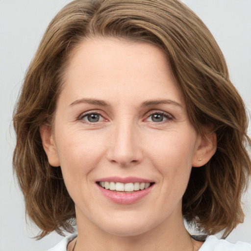 Joyful white young-adult female with medium  brown hair and green eyes