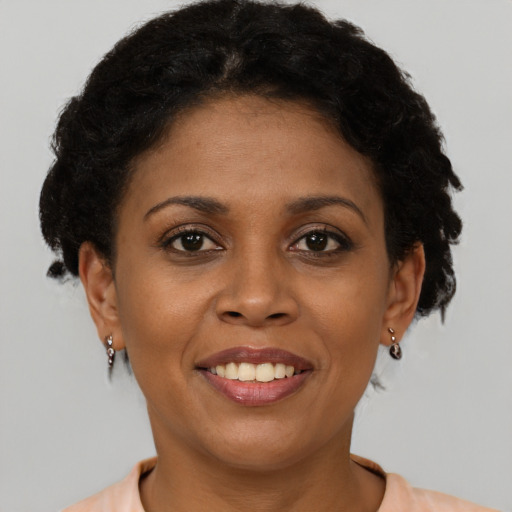 Joyful black young-adult female with short  brown hair and brown eyes