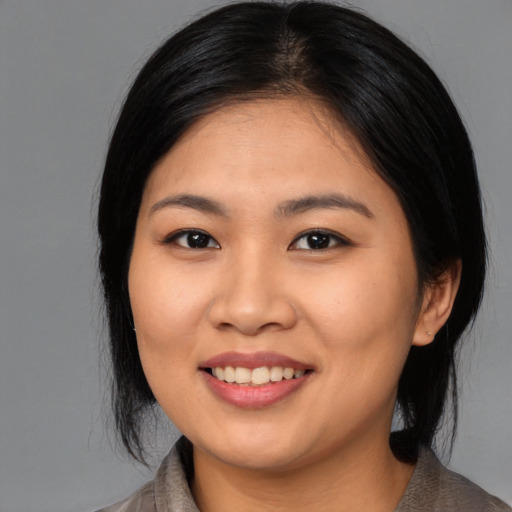 Joyful asian young-adult female with medium  black hair and brown eyes