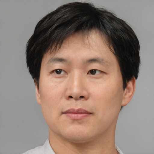 Joyful asian adult male with short  brown hair and brown eyes
