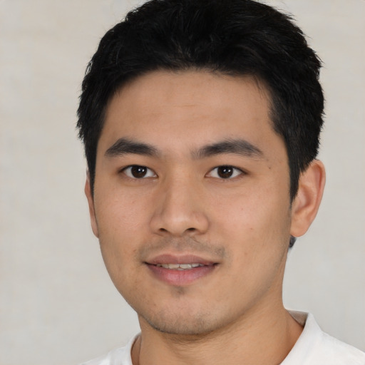 Joyful asian young-adult male with short  black hair and brown eyes