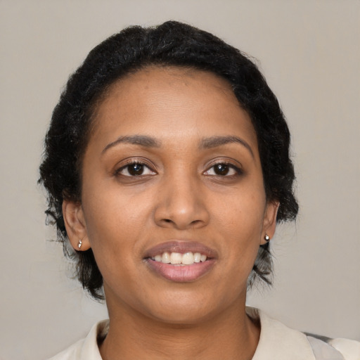 Joyful black young-adult female with medium  brown hair and brown eyes