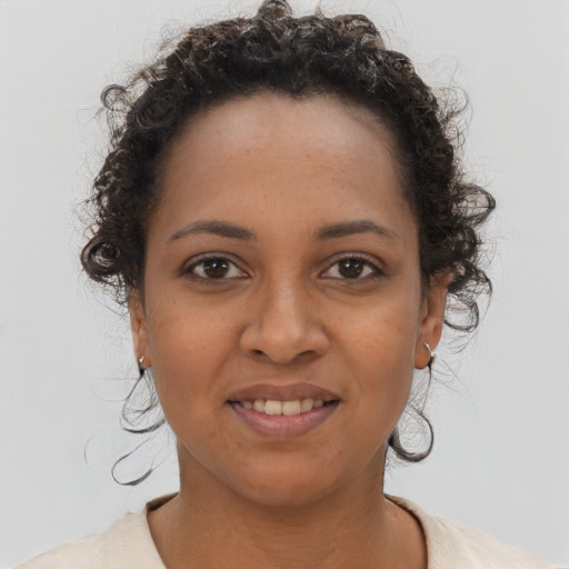 Joyful black young-adult female with short  brown hair and brown eyes