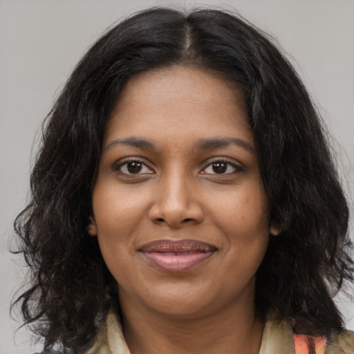 Joyful black young-adult female with medium  brown hair and brown eyes