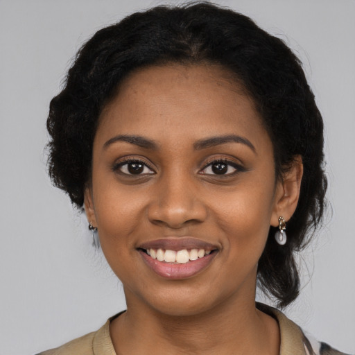 Joyful black young-adult female with long  black hair and brown eyes