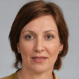 Joyful white adult female with medium  brown hair and grey eyes