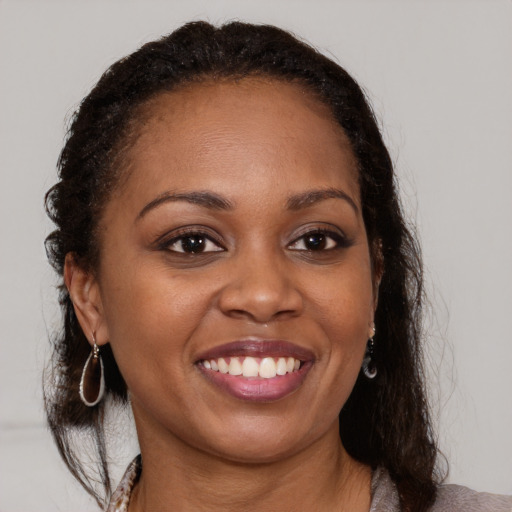 Joyful black young-adult female with medium  brown hair and brown eyes