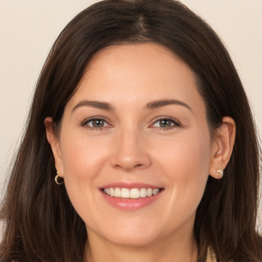 Joyful white young-adult female with long  brown hair and brown eyes