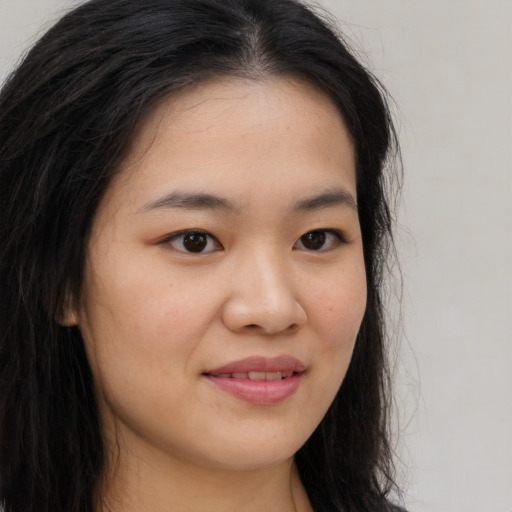 Joyful asian young-adult female with long  brown hair and brown eyes