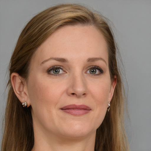 Joyful white adult female with long  brown hair and grey eyes