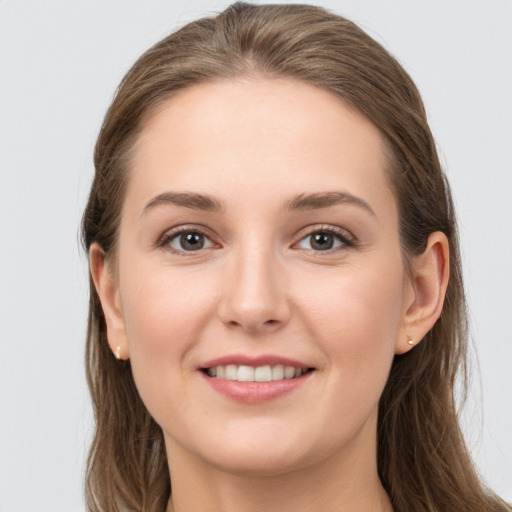 Joyful white young-adult female with long  brown hair and grey eyes