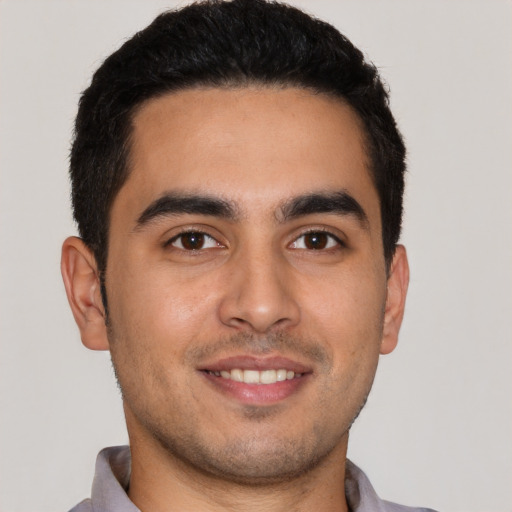 Joyful latino young-adult male with short  brown hair and brown eyes