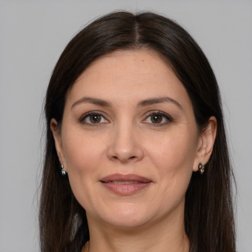 Joyful white adult female with long  brown hair and brown eyes