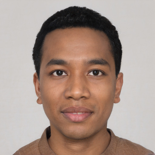 Joyful black young-adult male with short  black hair and brown eyes