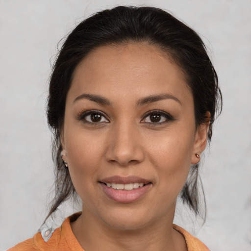 Joyful latino young-adult female with medium  brown hair and brown eyes
