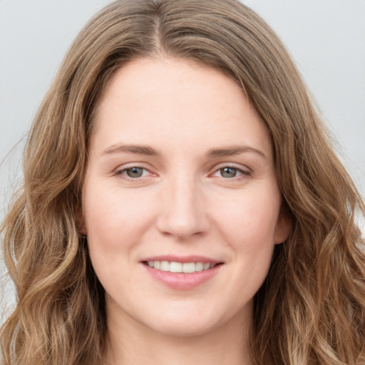 Joyful white young-adult female with long  brown hair and blue eyes