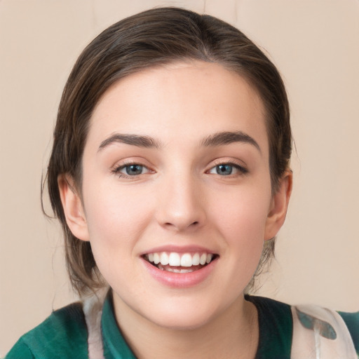 Joyful white young-adult female with medium  brown hair and green eyes