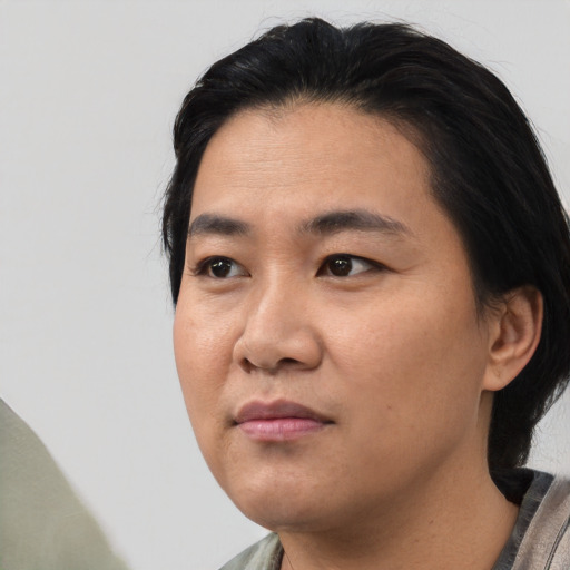 Joyful asian young-adult male with medium  black hair and brown eyes