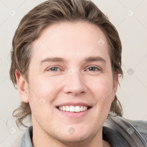 Joyful white young-adult male with short  brown hair and grey eyes