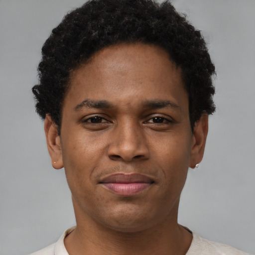 Joyful black young-adult male with short  brown hair and brown eyes