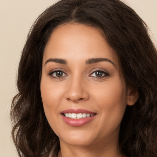 Joyful white young-adult female with long  brown hair and brown eyes