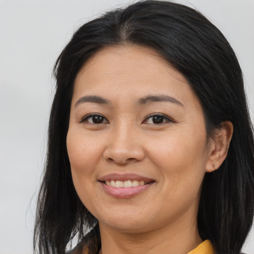 Joyful asian young-adult female with long  brown hair and brown eyes