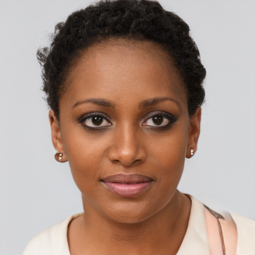 Joyful black young-adult female with short  brown hair and brown eyes