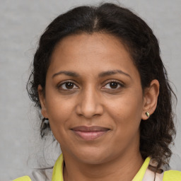 Joyful black adult female with medium  brown hair and brown eyes